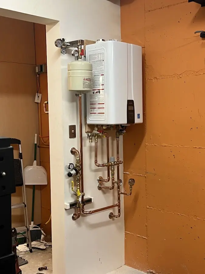 Plumbing technician inspecting water heater connections in Gages Lake